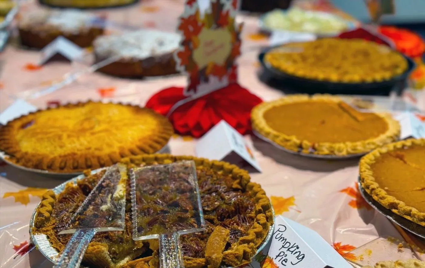 A table of homemade pies at a Thanksgiving gathering