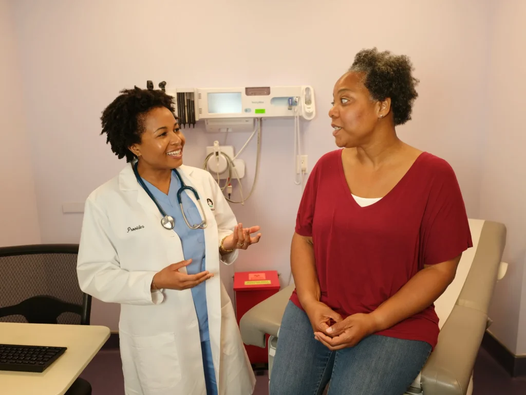 A Floating Hospital clinician talks with a patient in an exam room