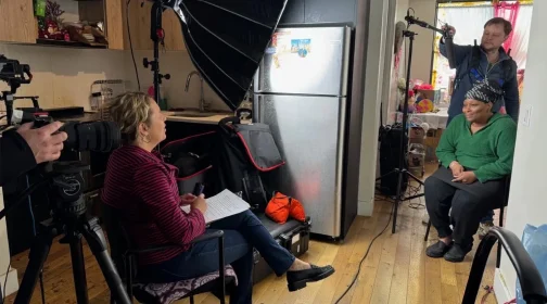 A video shoot in progress with lighting equipment and crew