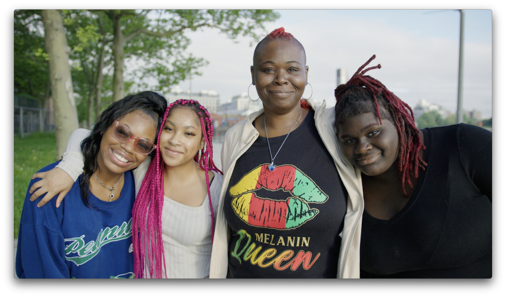 Delexis stands outdoors with her three children, all smiling