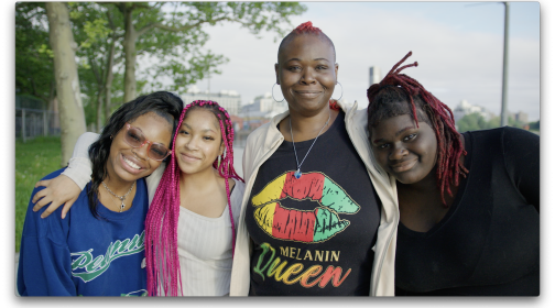 Delexis stands outdoors with her three children, all smiling