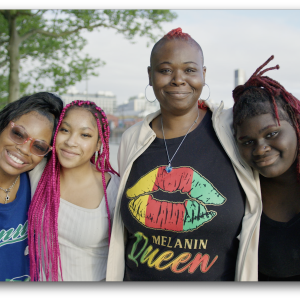 Delexis stands outdoors with her three children, all smiling